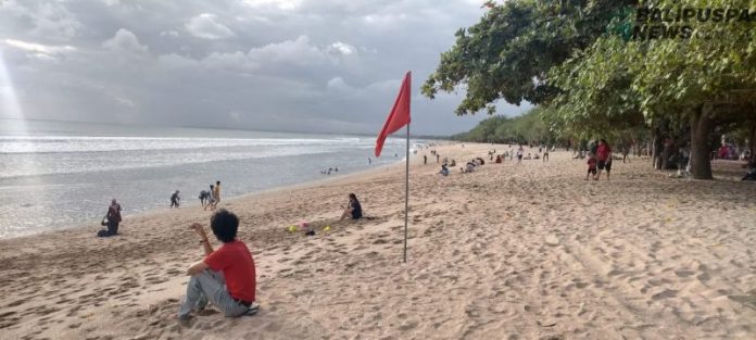 Terlihat masyarakat mulai mengunjungi Pantai Kuta di hari pertama New Normal pada, Kamis (9/7/2020).