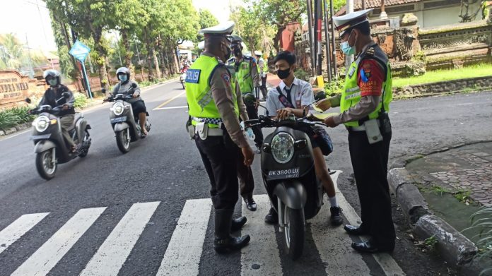 Polisi saat menegur pengendara sepeda motor yang tidak pakai helm