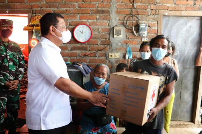 Wakil Bupati yang juga Ketua PMI Buleleng I Nyoman Sutjidra saat menyerahkan bantuan kepada keluarga terdampak longsor di Desa Bebetin, Kecamatan Sawan