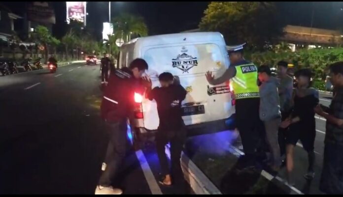Personel Polres Kawasan Bandara I Gusti Ngurah Rai bersama warga sekitar mengevakuasi sebuah mobil box Grandmax putih yang mengalami kecelakaan tunggal