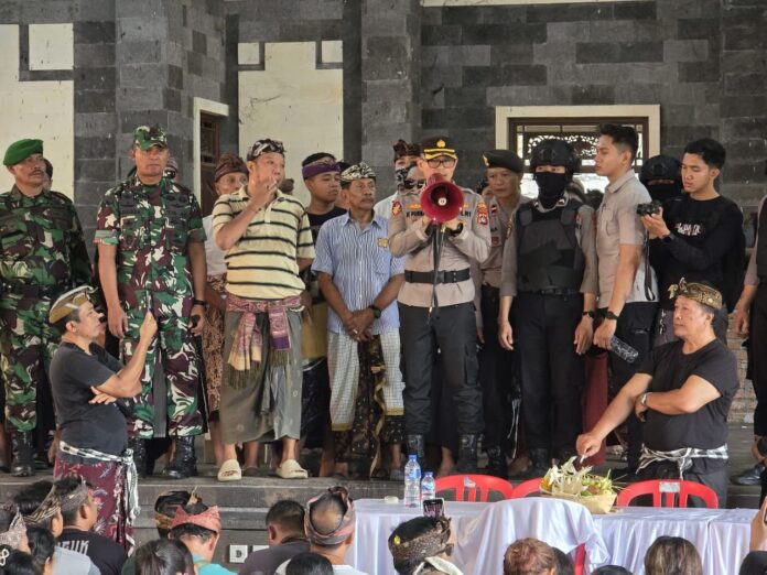 Pihak keamanan menghentikan paruman agung Desa Adat Bugbug yang memanas