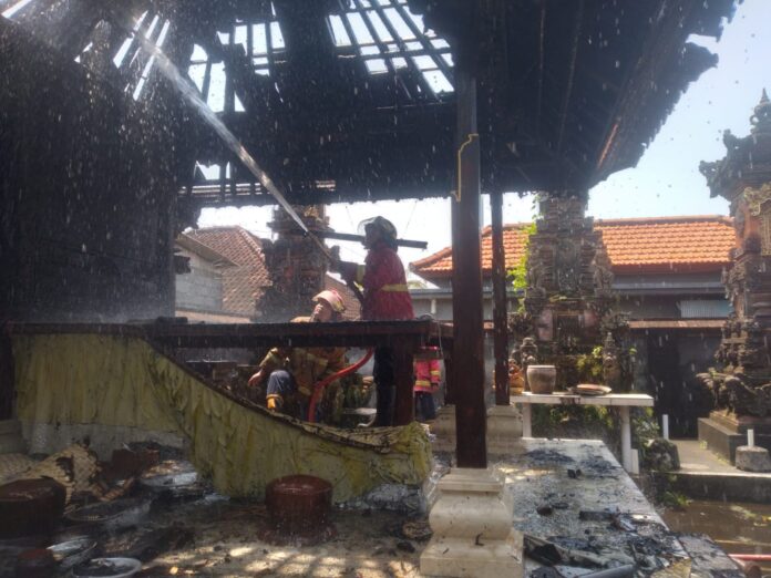 Petugas pemadam sedang berusaha memadamkan api yang membakar Piasan Pura Melanting Banjar Kutri, Singapadu, Tengah, Sukawati