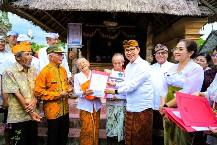 Bupati Badung I Wayan Adi Arnawa bersama Ketua TP PKK Badung Nyonya Rasniathi Adi Arnawa saat menyerahkan penghargaan kepada 187 veteran di Desa Baha, Kecamatan Mengwi, Jumat (19/12/2025)