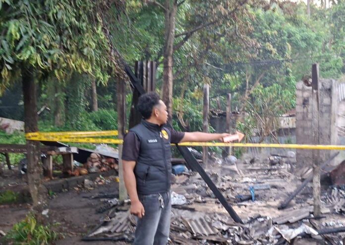 Polisi pasangan police line di lokasi warung terbakar Banjar Nyuhtebel, Manggis, Karangasem
