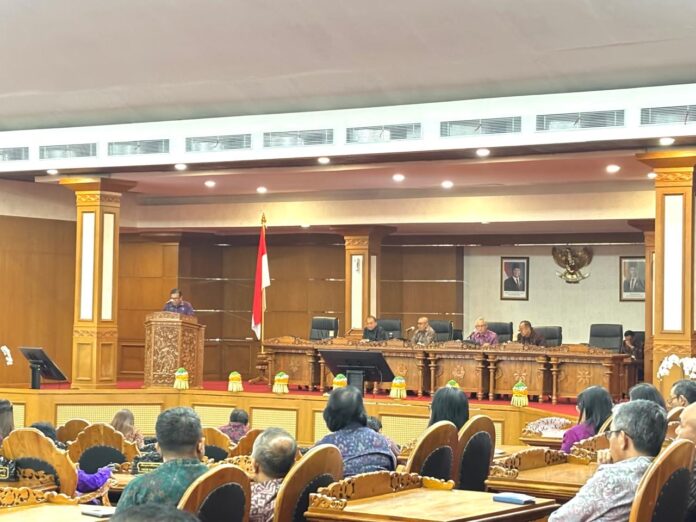 Gede Harja Astawa membacakan pandangan Umum terhadap dua Rancangan Peraturan Daerah (Raperda) tentang Tata Kelola Usaha Pariwisata Bali Berkualitas; Perubahan Atas Peraturan Daerah Nomor 1 Tahun 2024 tentang Pajak Daerah dan Retribusi Daerah Fraksi Gerindra-PSI DPRD Provinsi Bali dalam Rapat Paripurna Ke-33 yang berlangsung di Ruang Sidang Utama Gedung DPRD Provinsi Bali
