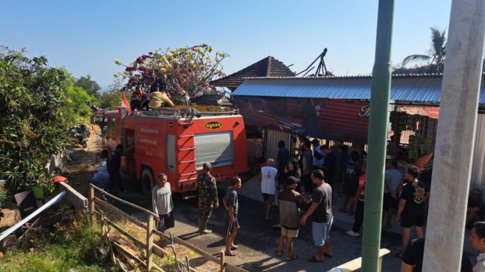 Petugas pemadam kebakaran dibantu warga saat memadamkan api yang membakar rumah di Banjar Dinas Pegentengan, Desa/Kecamatan Banjar, Buleleng